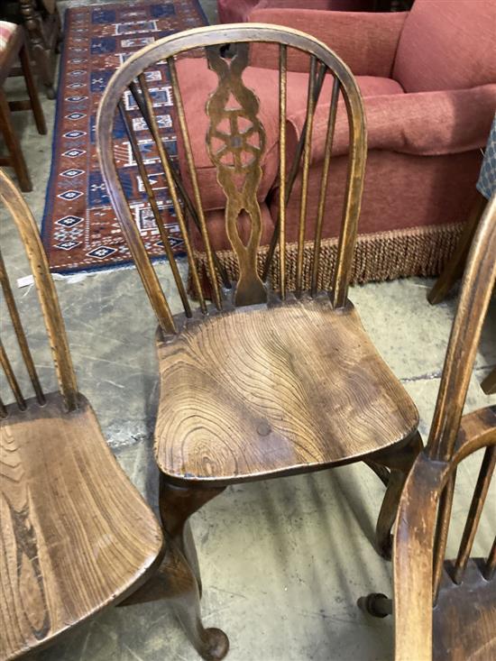 A set of eight early 20th century elm and beech Windsor wheelback dining chairs, with crinoline stretchers (two with arms)